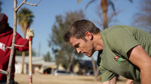 Guy planting a tree.