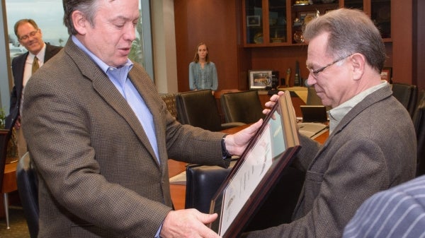 man presenting a certificate to a professor