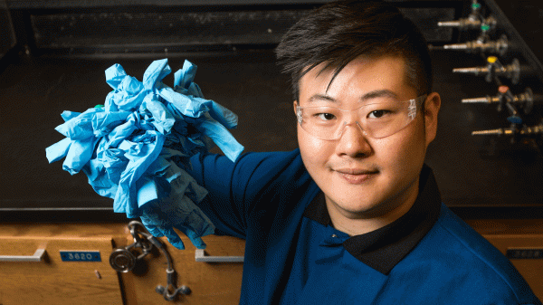 A student holds a pile of lab gloves.