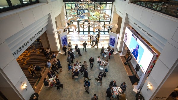 People walk a hallway at a conference.