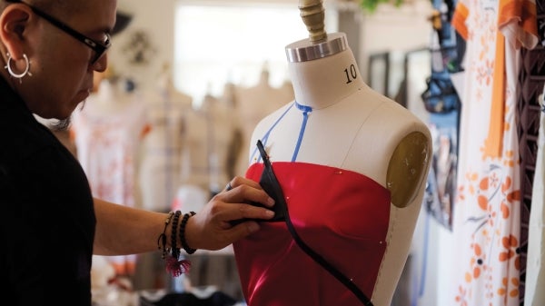 Designer Loren Aragon works on a dress on a dressmaker mannequin