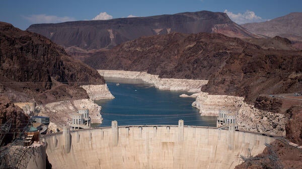 An aerial photo of Lake Mead behind Hoover Dam showing white sections where the water level has drastically receded