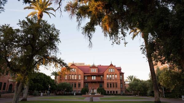 Picture of Old Main from far away with surrounding trees and greenery.