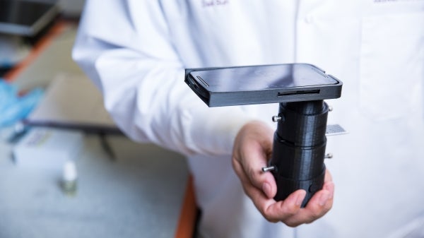 man holding microscope for a mobile phone