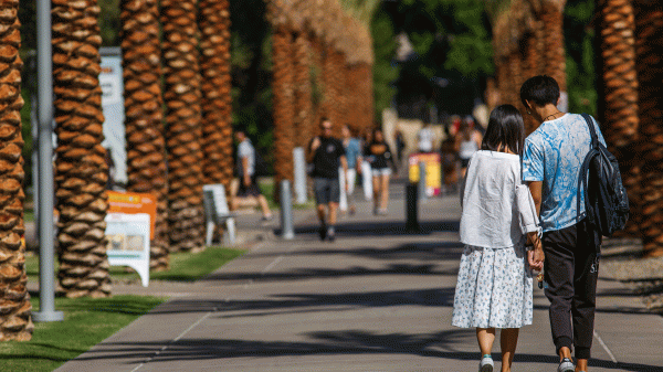 Couple holds hands on Palm Walk