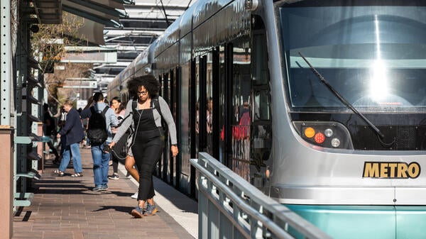 people getting off light rail car at station