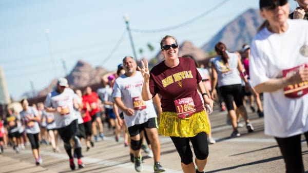 woman making pitchfork sign during Pat's Run race