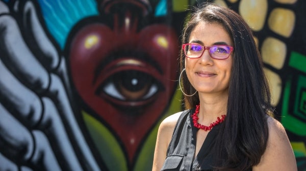 Woman in glasses next to mural