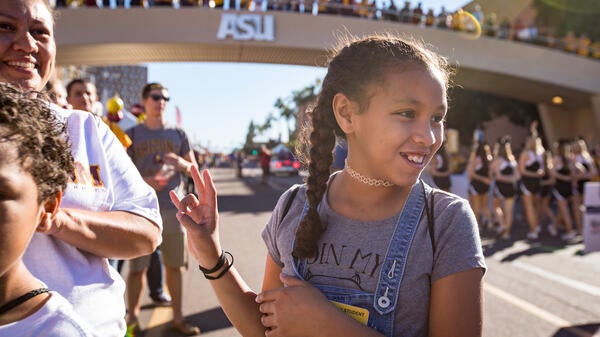 girl making pitchfork sign with hand at ASU Homecoming parade