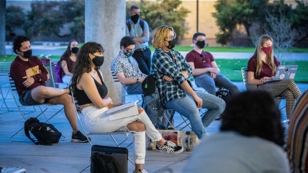 Students sit socially distanced outside to discuss the election