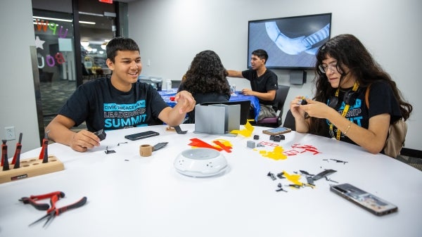 students sitting at table putting together 3D models