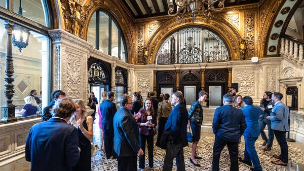 A crowd of people mingle in the ornate lobby of the Herald Examiner building in LA