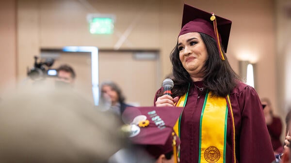 Graduate tearfully talks to group at event