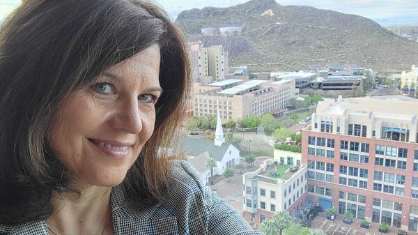 Portrait of archaeologist Donna Nash in front of a window smiling.