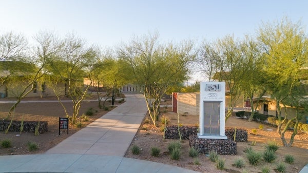 A sign with the letters "ASU" among landscaping on the ASU at Lake Havasu campus.