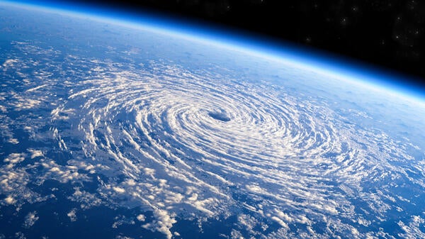 A hurricane forming above an ocean as seen from space.