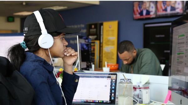 Person seated at a desk wearing headphones.