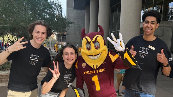 Three ASU Space Ambassadors pose with Sparky 