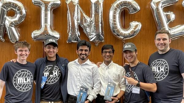 Group of men standing for group picture holding trophies.