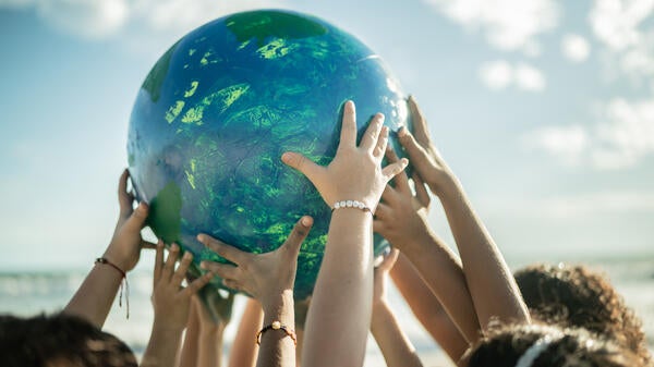 Kids hands holding up globe