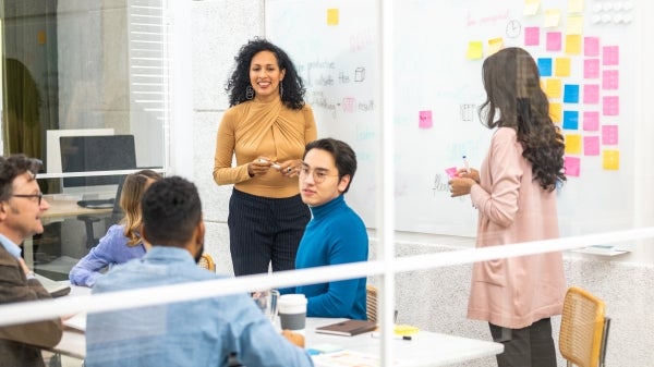 People in a conference room with sticky notes and writing on whiteboards