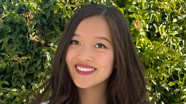 A brunette woman smiles for the camera.