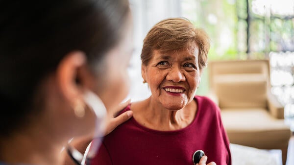 Doctor listening to a woman's heartbeat with a stethoscope.