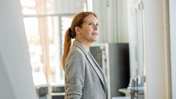 Portrait of a woman with reddish brown hair wearing a gray blazer