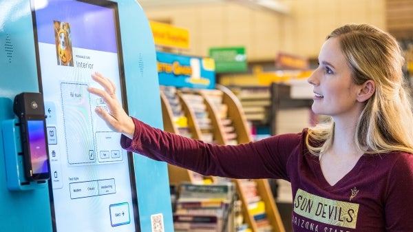 A woman touches a large computer screen