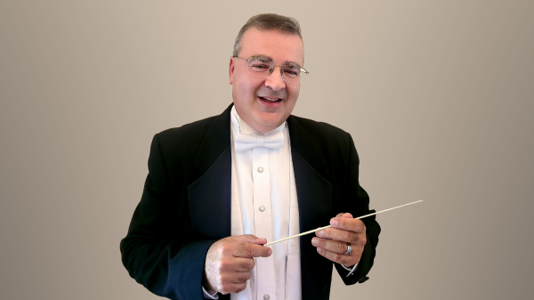 Ron Spigelman in a formal suit with a conductor's baton.