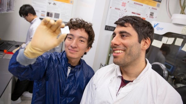 Two scientists in a lab observe a microchip.