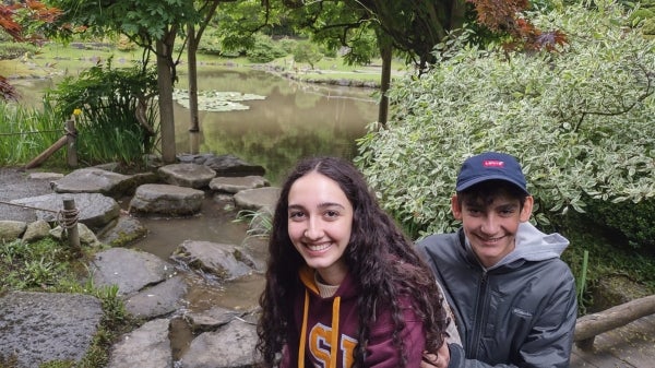 Two people smile in an outdoor setting.