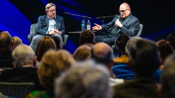 Michael Crow and Bob Parsons seated onstage speaking to an audience.