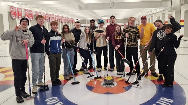 A group of students pose with sports equipment