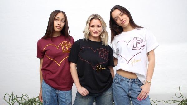 Three students wearing T-shirts with heart graphics on them.