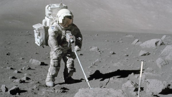 Astronaut collecting samples from the surface of the moon.