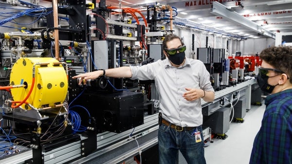 ASU Assistant Professor Samuel Teitelbaum stands in front of the compact X-ray light source instrument.