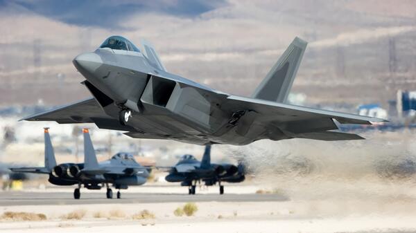 Large U.S. military aircraft taking off from a runway.