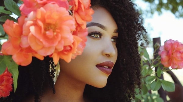 Graduating ASU student Ashai Thomas, surrounded by flowers / Courtesy photo