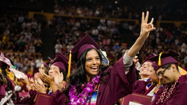 student at ASU Hispanic Convocation making a pitchfork with her hand