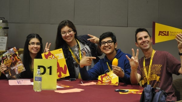 group of high school students and teacher holding ASU banners at conference