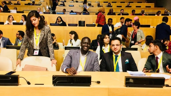 Bandak Lul seated next to youth delegate from Pakistan