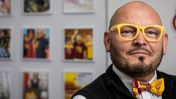 Shawn Banzhaf, assistant director of student success in the Pat Tillman Veterans Center at Arizona State University, poses for a photo in ASU gold glasses and ASU themed bowtie.