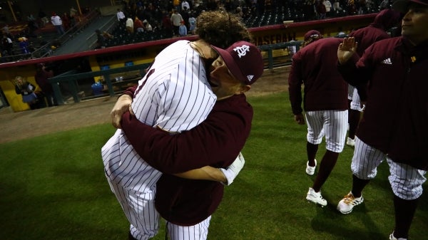 Coach hugging baseball player