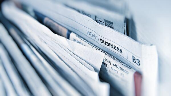 Stack of newspapers with business section sticking out