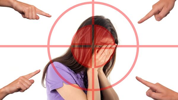 fingers pointing at a woman covering her face in shame