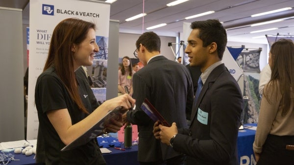 student talking to an employer at a career fair