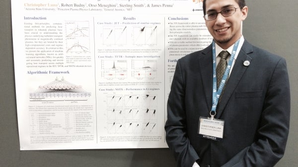 student standing in front of research presentation