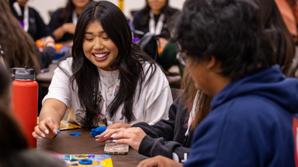 Christine Peralta sitting at a table with other students.