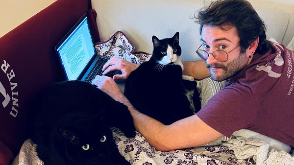 Graduating ASU student Colin Bonini works on his fiction while surrounded by ever-present writing partners.